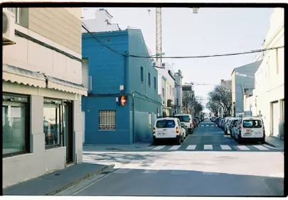 Vibrant Blue Building Dominates Sunny European Street Scene