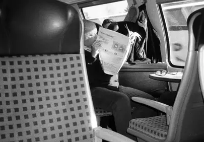 Timeless Journey: Man Lost in News on a Moving Train