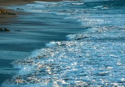 Dramatic Sunset Beach: Waves Crash on a Serene Coast