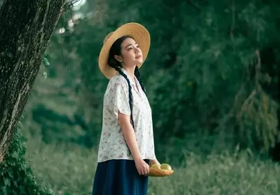 Serene Summer Day: Woman in Hat Beneath Guava Tree