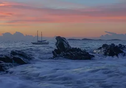 Dramatic Sunset Seascape with Yacht and Crashing Waves