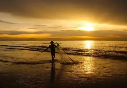 Golden Dawn: Fishermen Cast Nets on Tranquil Beach