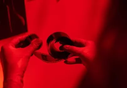 Enigmatic Red: Hands Developing Film in a Darkroom