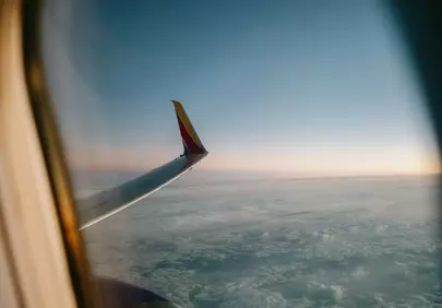 Breathtaking Sunset Flight: Wing Above the Clouds
