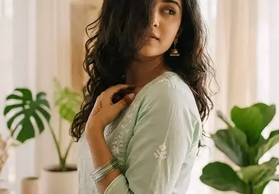 Serene Asian Woman in Traditional Attire Amidst Greenery