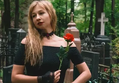 Gothic Elegance: Woman with Red Rose in a Mysterious Cemetery