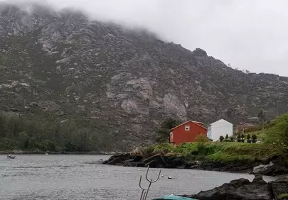 Serene Coastal Retreat: A Fishing Boat on a Misty Shore