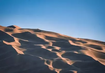 Breathtaking Desert Dunes: Golden Sands Under a Clear Blue Sky
