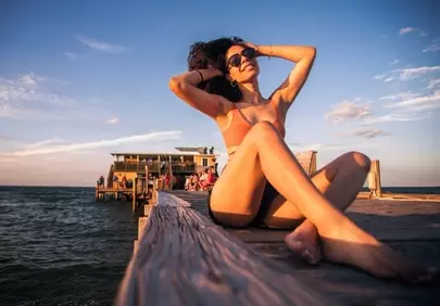 Stunning Sunset Serenity: Woman Relaxing on a Coastal Pier