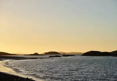 Serene Sunset: Tranquil Ocean View with Silhouetted Islands