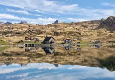 Breathtaking Alpine Panorama: Serene Lake Reflects Mountain Village