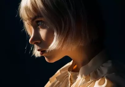 Stunning Light Play: Emotive Blonde Portrait on Dark Background
