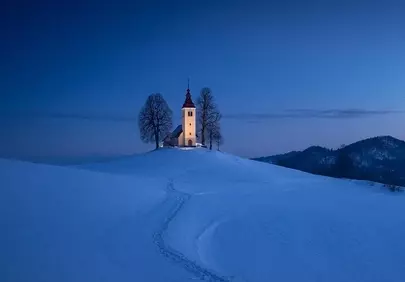 Enchanting Winter Wonderland: Solitary Church Under Blue Hour Sky