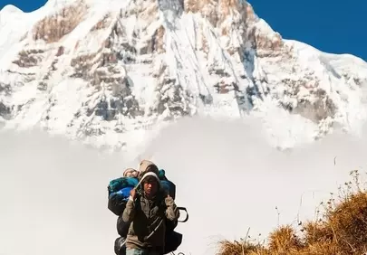 Himalayan Porter's Ascent: Majestic Annapurna Backdrop