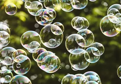 Vibrant Iridescent Bubbles Floating Against Green Foliage