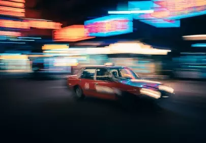 Vibrant Night Blur: Red Taxi in Neon Cityscape