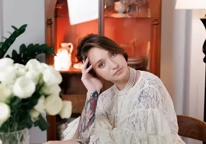 Elegant Serenity: Woman in Lace and Pearls Amidst White Roses