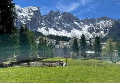 Majestic Alpine Vista: Serene Cottages Amidst Snow-Capped Peaks