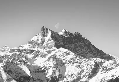 Majestic Alpine Peaks Under a Crescent Moon