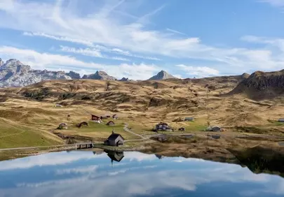 Serene Alpine Reflection: Mountain Lake & Village Panorama