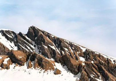 Majestic Peaks: Snow-Kissed Mountains Under Clear Skies