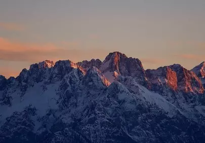 Dramatic Alpine Dawn: Snow-Capped Peaks Ablaze with Sunrise Glow