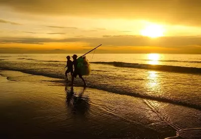 Golden Dawn: Fishermen's Silhouettes Against a Radiant Sunrise Sea