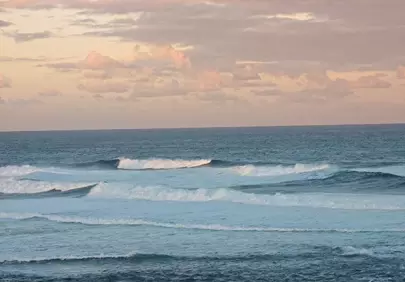 Serene Coastal Sunset: Waves Kissing the Horizon