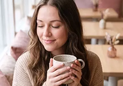 Cozy Morning Bliss: Woman Enjoys Coffee in Serene Cafe