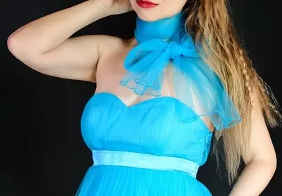Stunning Blonde in Radiant Blue Gown on Dark Background