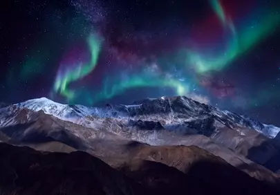 Breathtaking Aurora Borealis Dances Over Majestic Snowy Peaks