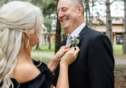 Joyful Moments: Woman Adorns Man's Suit with Boutonniere