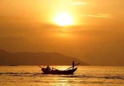 Golden Dawn: Fishermen on Tranquil Waters at Sunrise