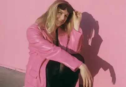 Vibrant Pink: Stylish Woman Poses Against Bold Wall