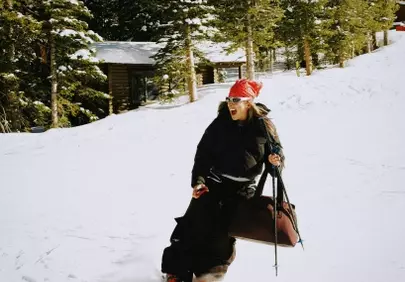 Thrilling Ski Descent: Woman Conquering Snowy Slopes with Bag