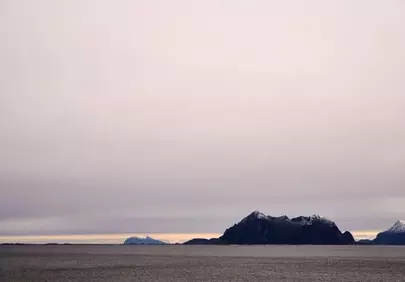 Serene Northern Twilight: Majestic Mountains Meet Calm Sea