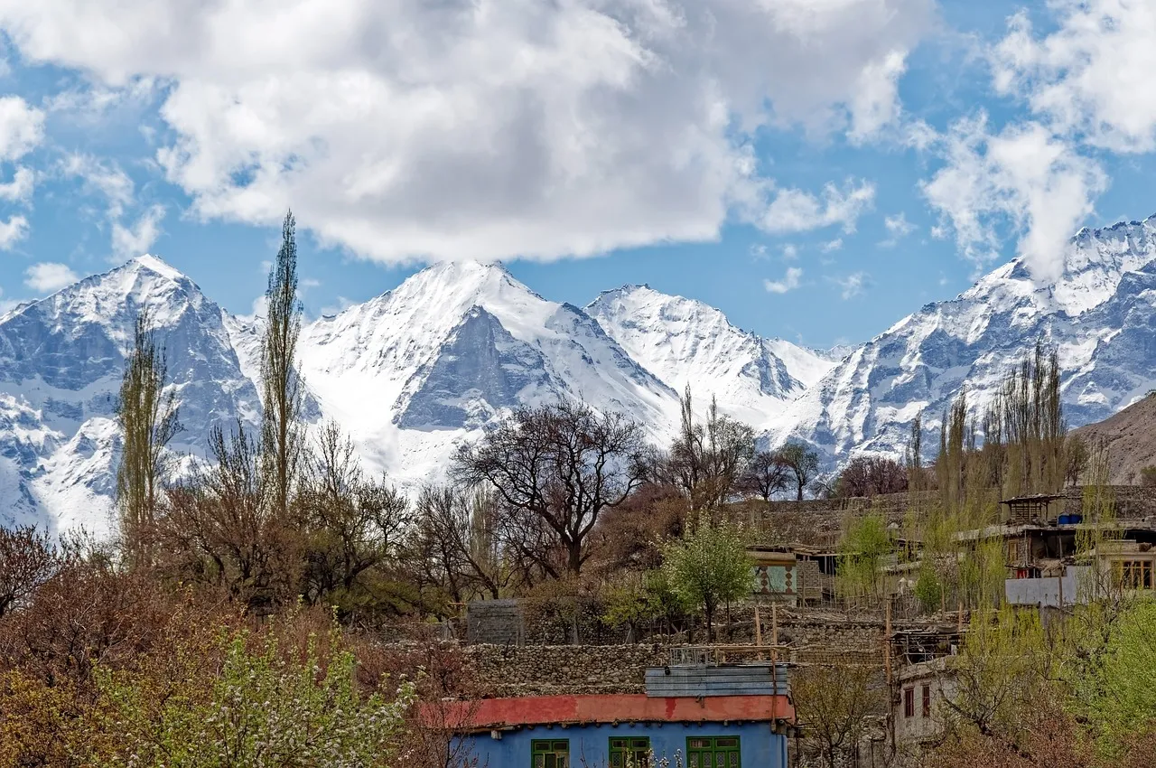 Majestic Karakoram Peaks: Serene Village Life Under Snowy Giants