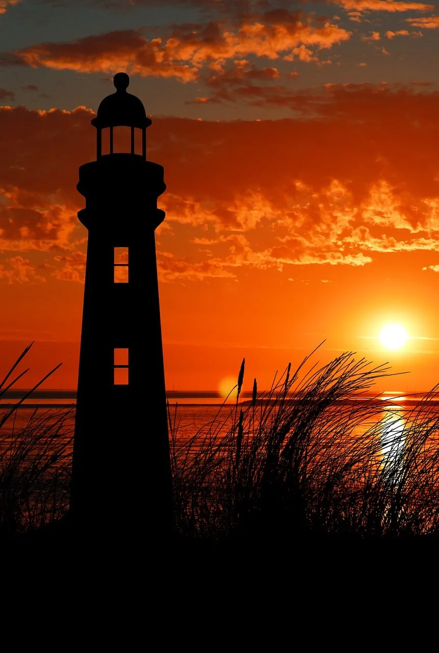 Dramatic Coastal Glow: Lighthouse Silhouette at Sunset