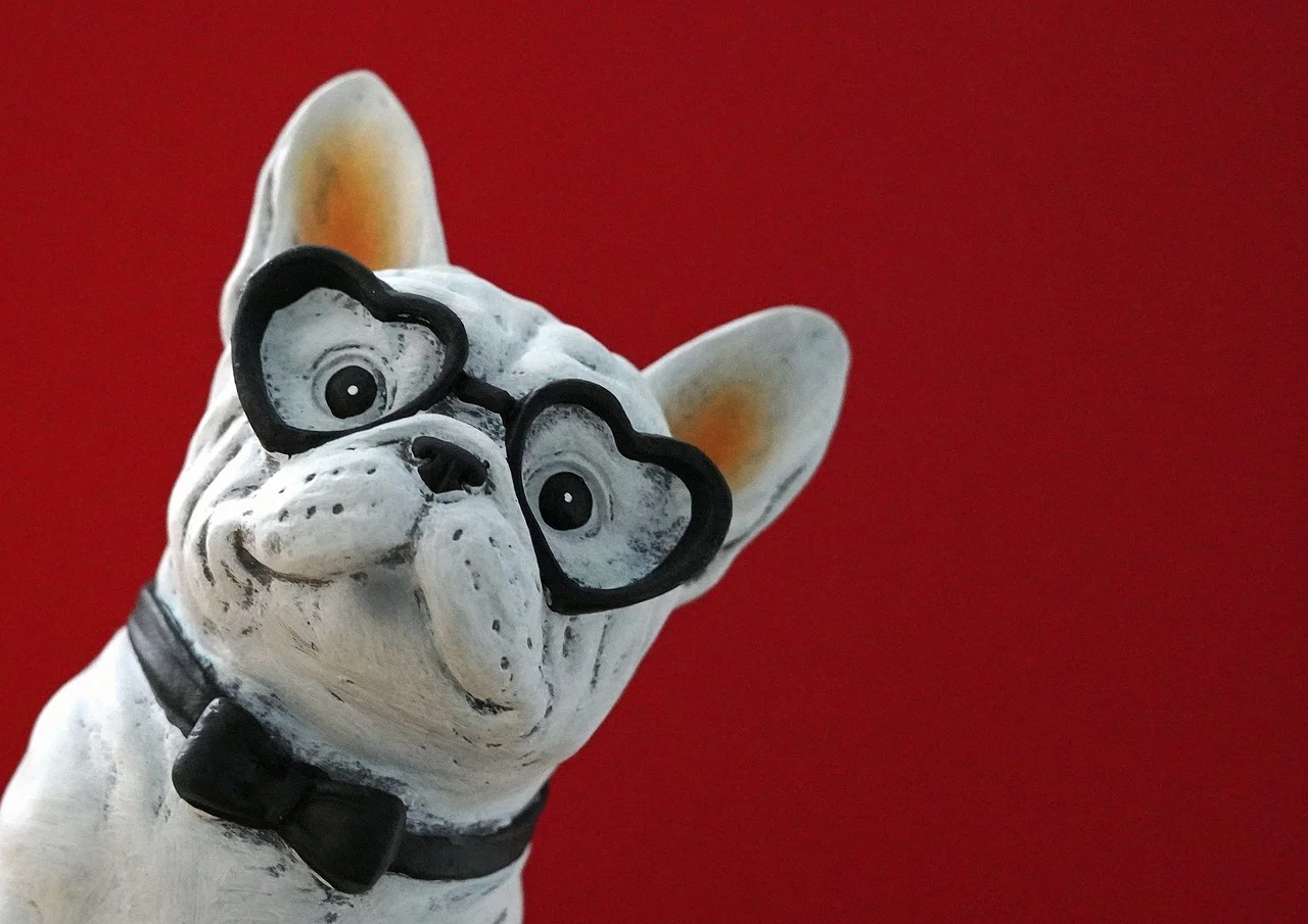 Charming French Bulldog Figurine with Heart Glasses on Red Background