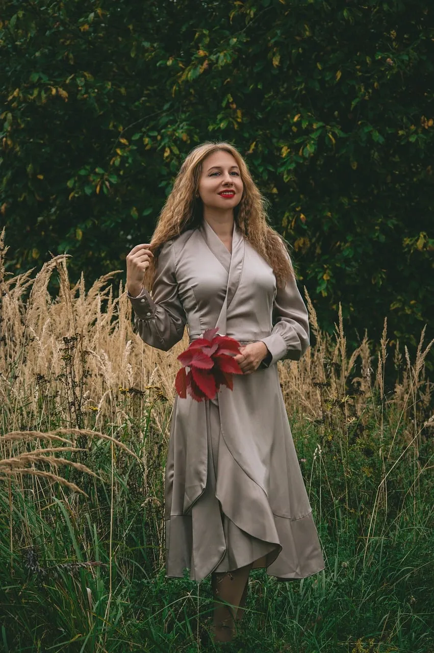 Enchanting Autumn Portrait: Woman in Field with Fiery Leaves