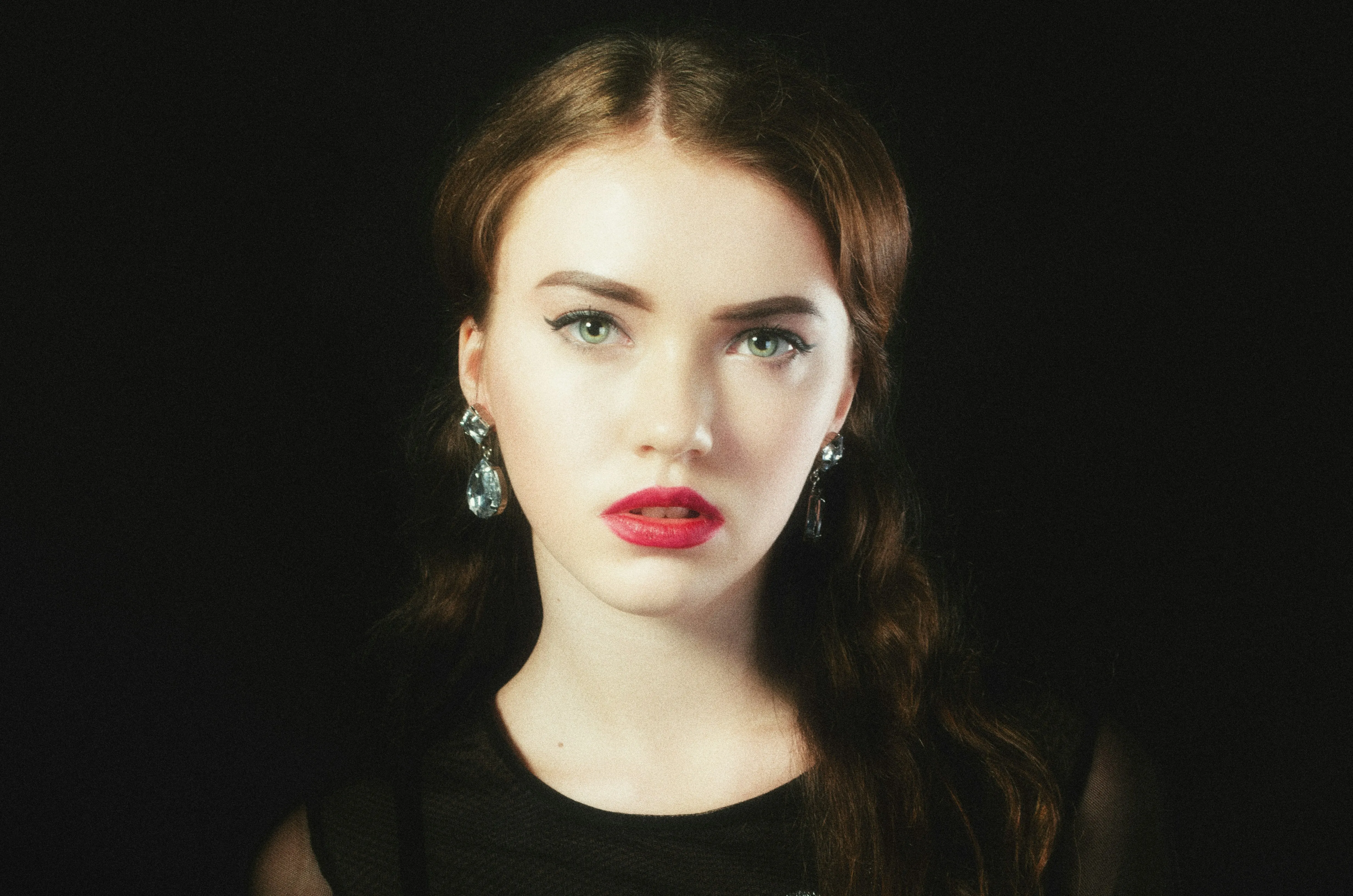 Striking Beauty: Young Woman with Vivid Red Lipstick and Elegant Earrings