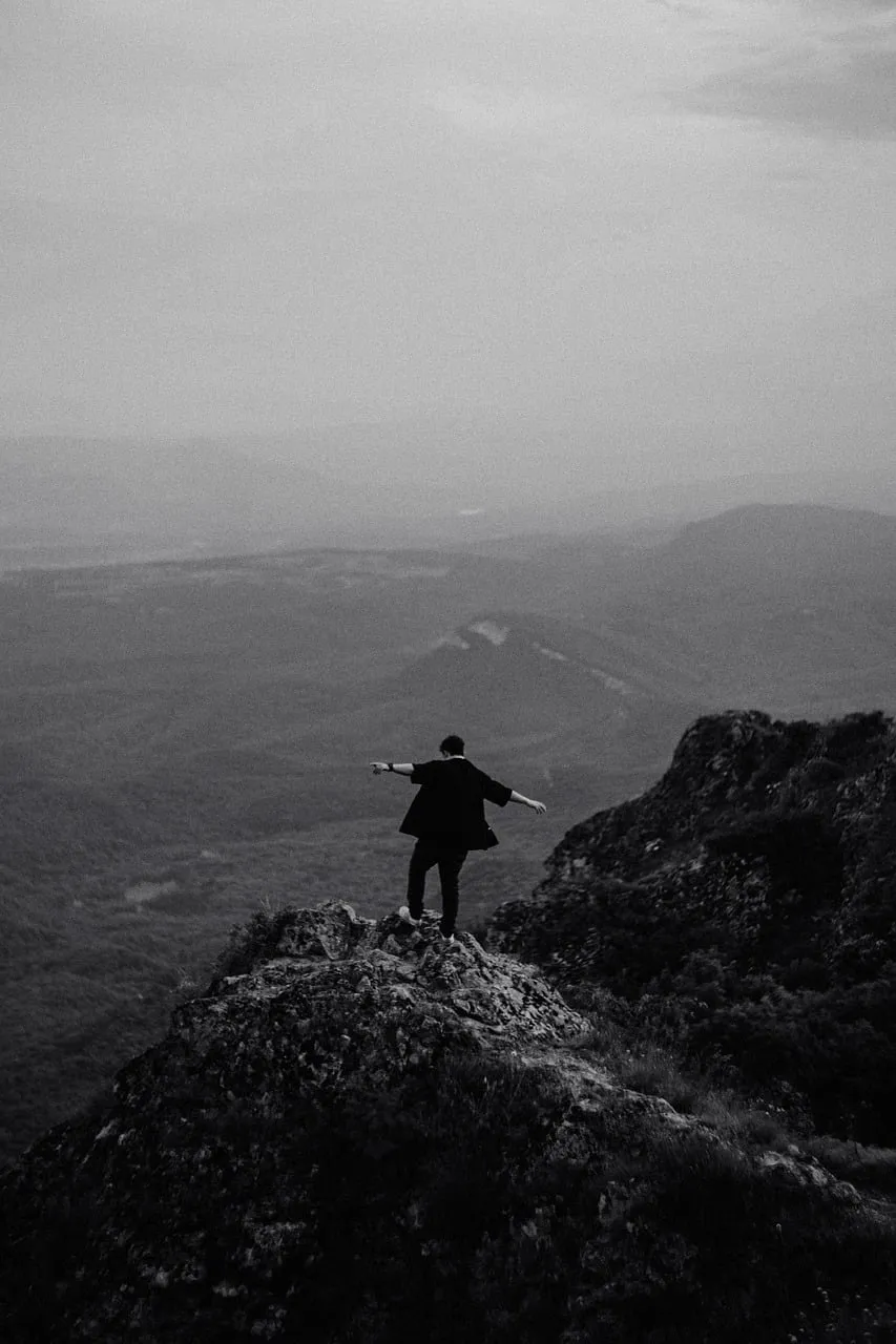 Dramatic Solitude: Hiker's Freedom on Misty Mountain Cliff