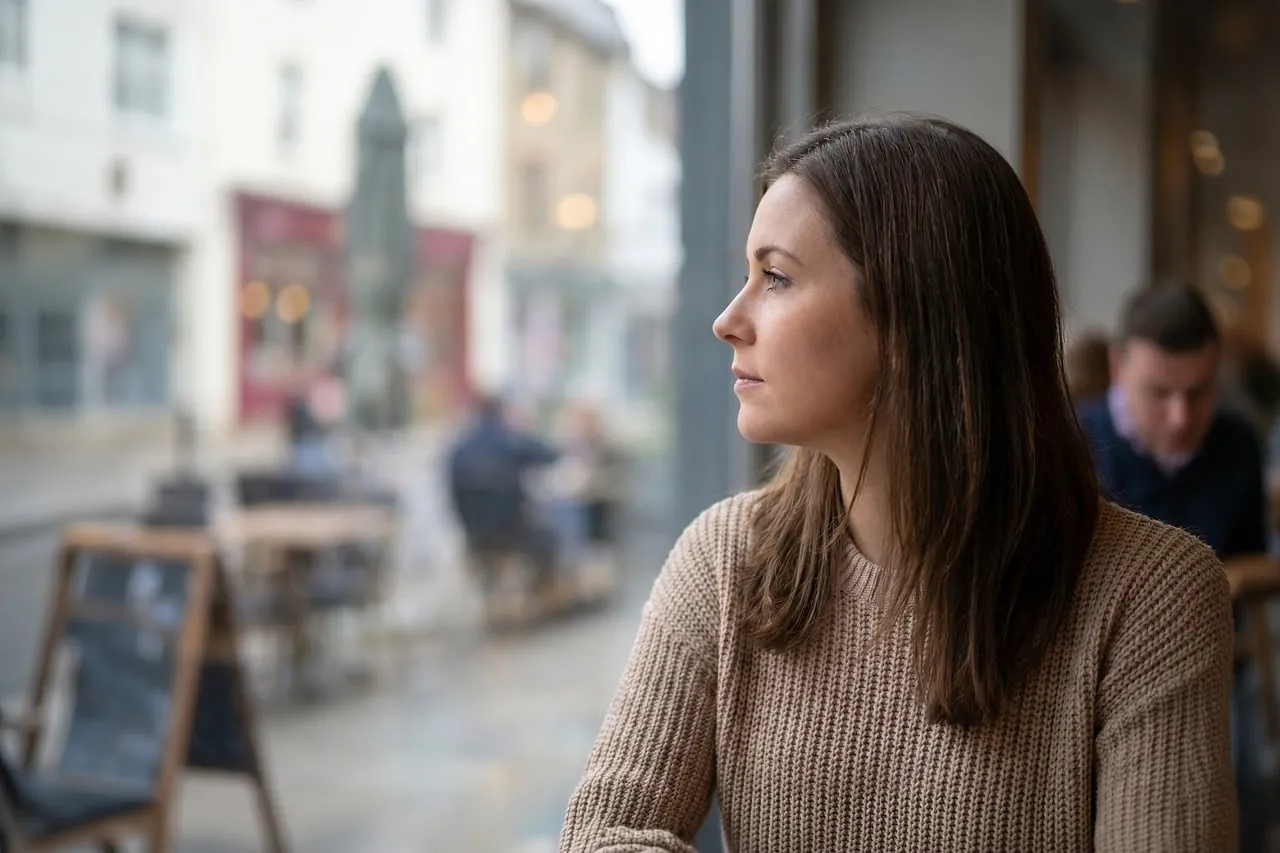 Serene Café Contemplation: Young Woman's Thoughtful City View