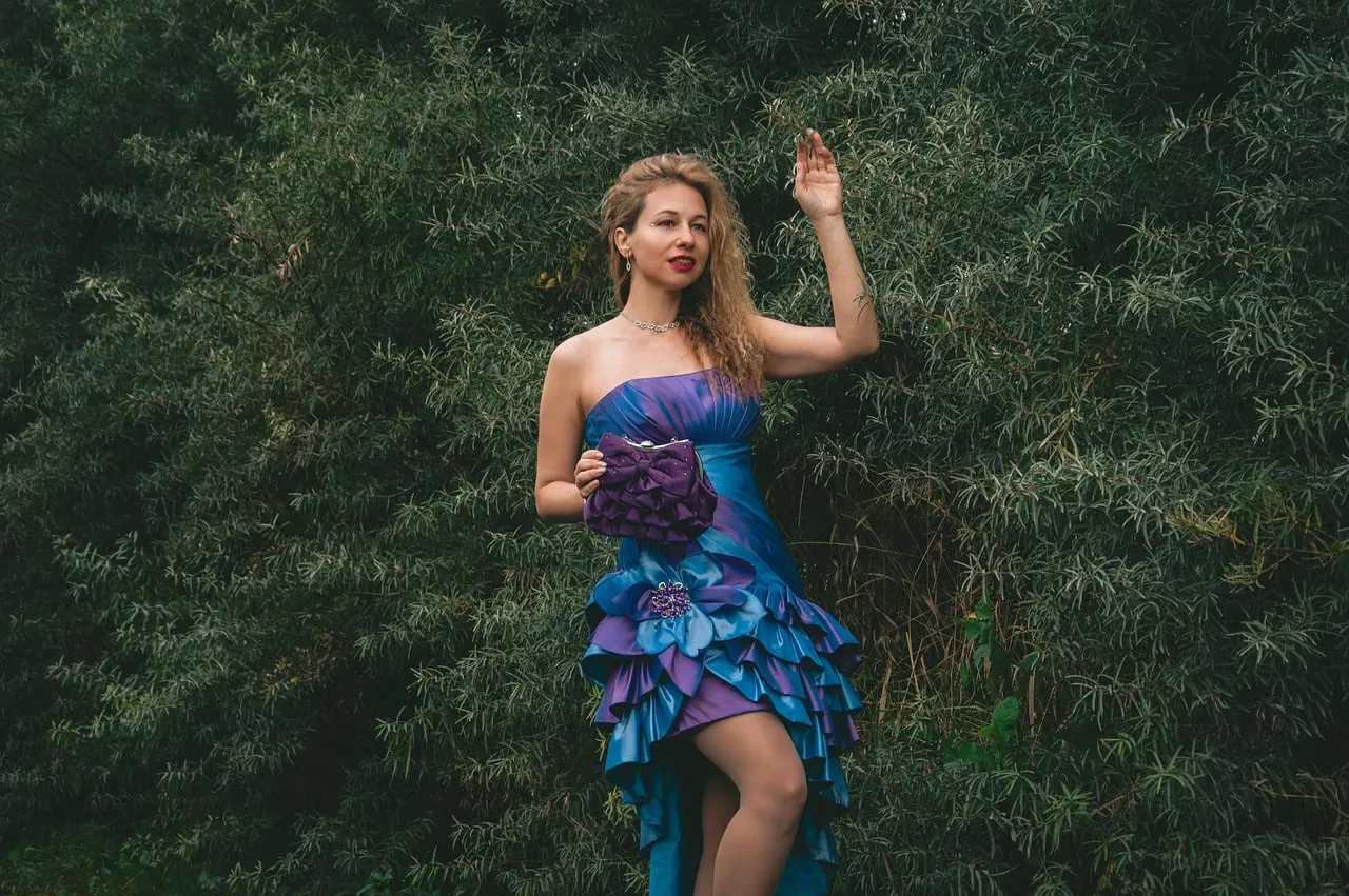 Enchanting Blonde in Purple Evening Gown Amidst Lush Nature