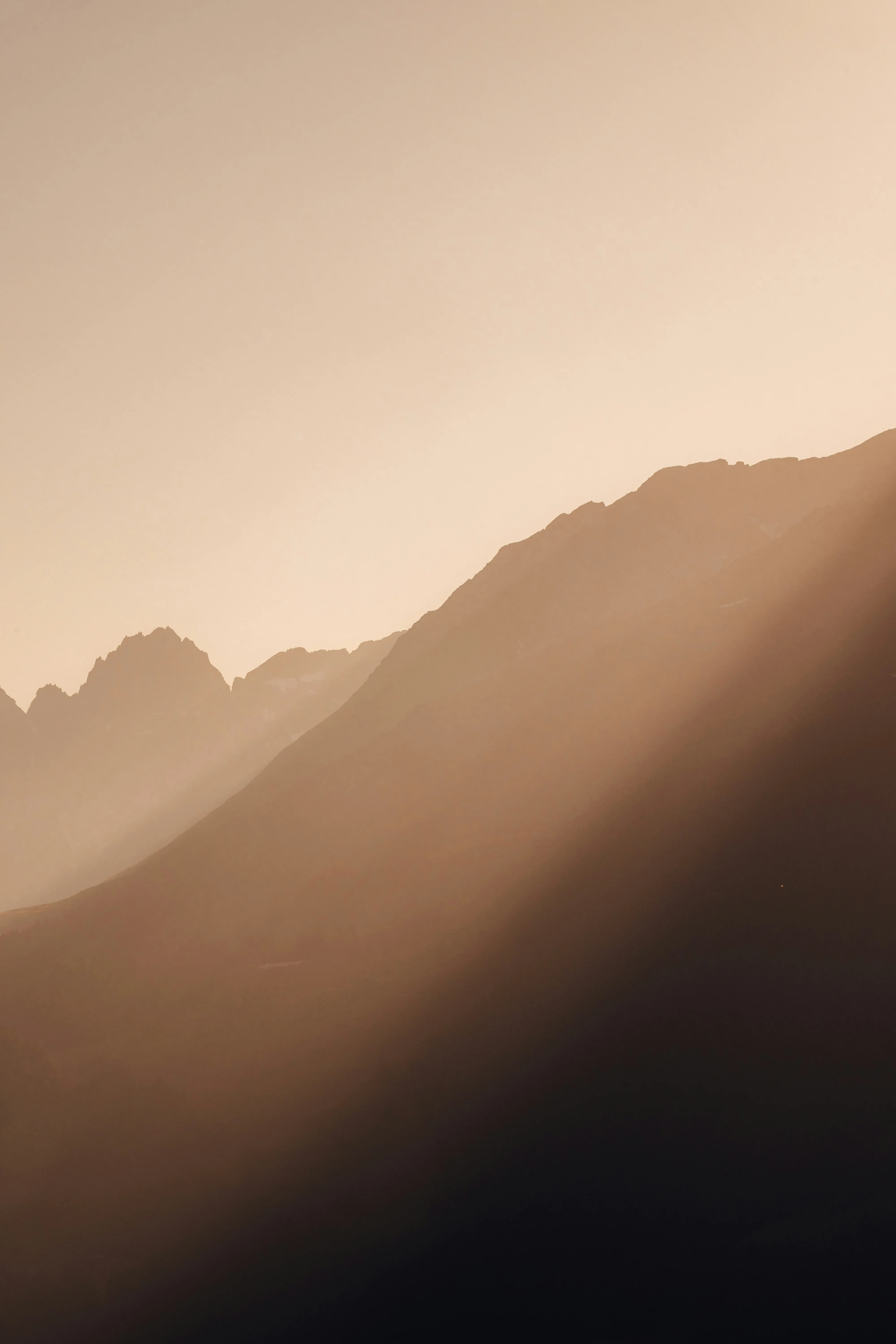 Dramatic Sunbeams Illuminate Majestic Mountain Silhouettes