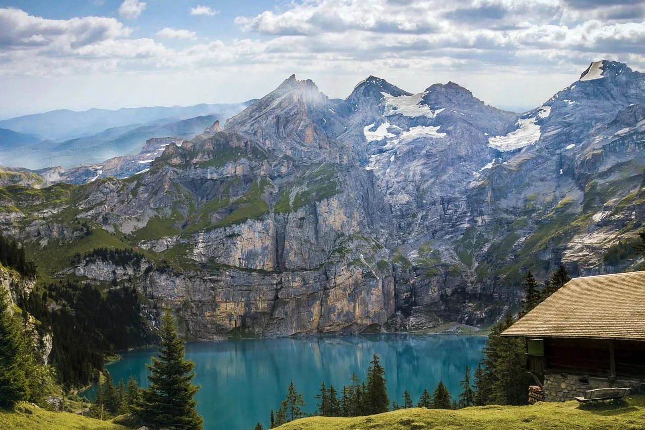 Breathtaking Alpine Panorama: Serene Lake & Mountain Cabin