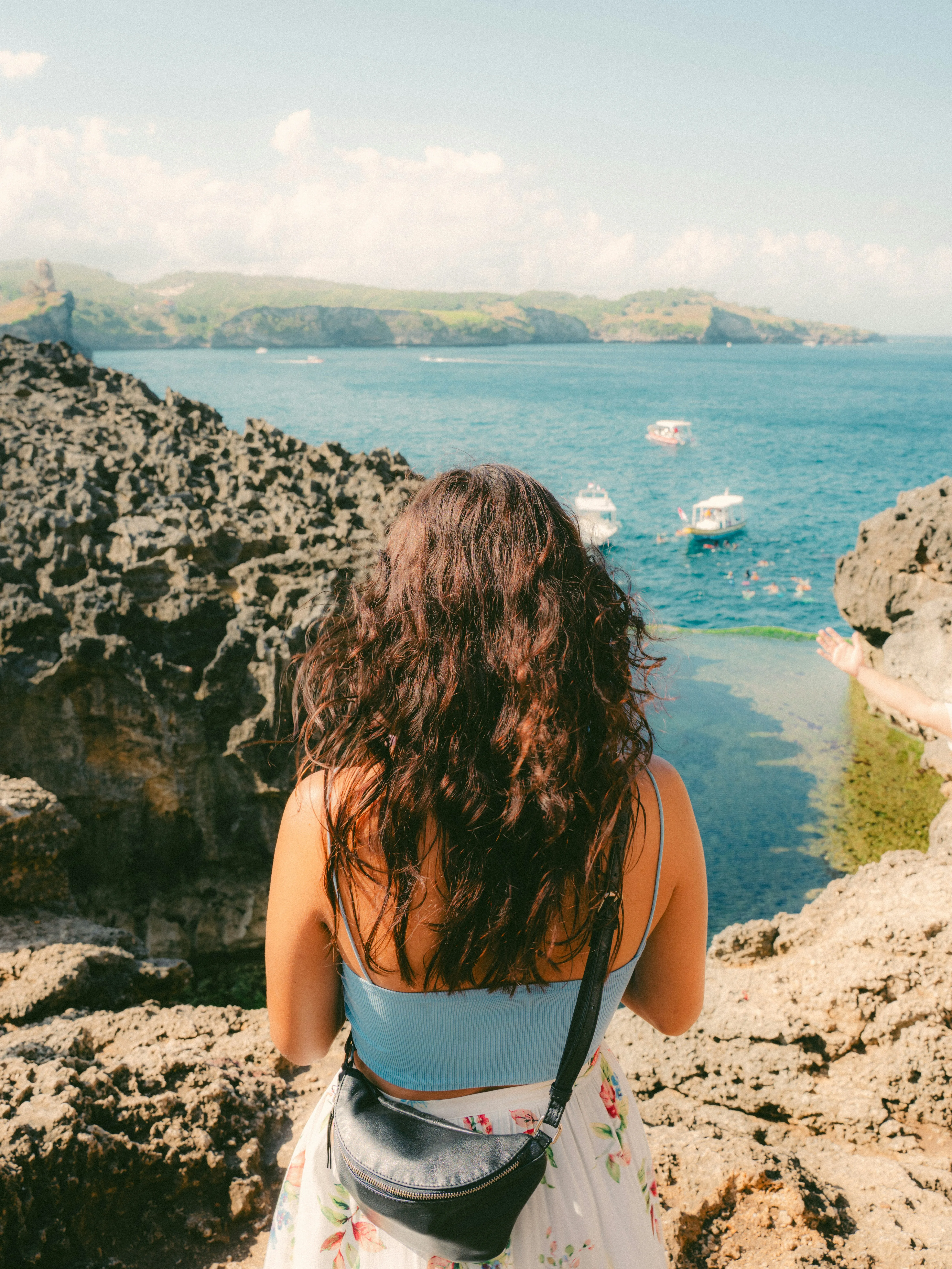 Breathtaking Coastal Vista: Woman Gazing at Serene Blue Waters and Boats