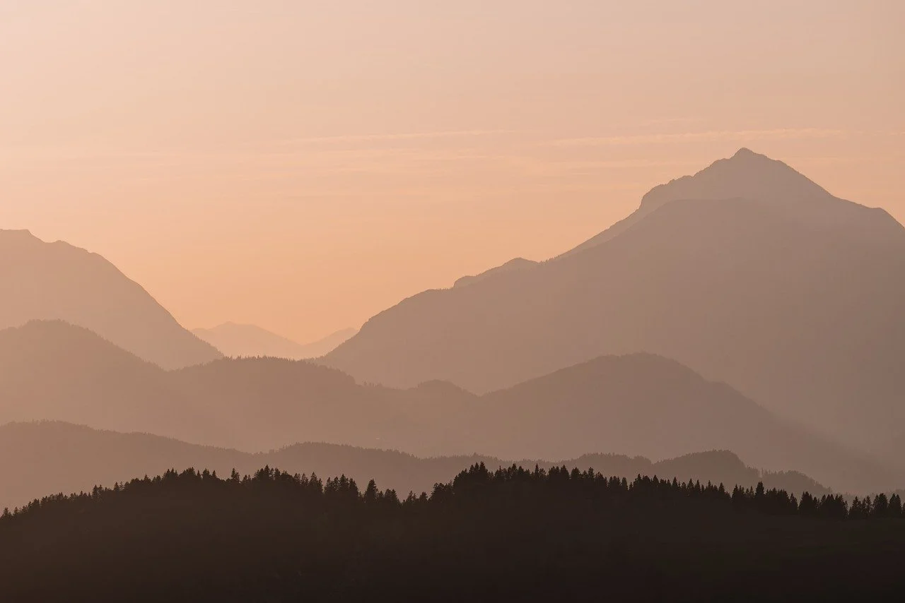 Serene Dawn: Layers of Mountains Bathed in Golden Light