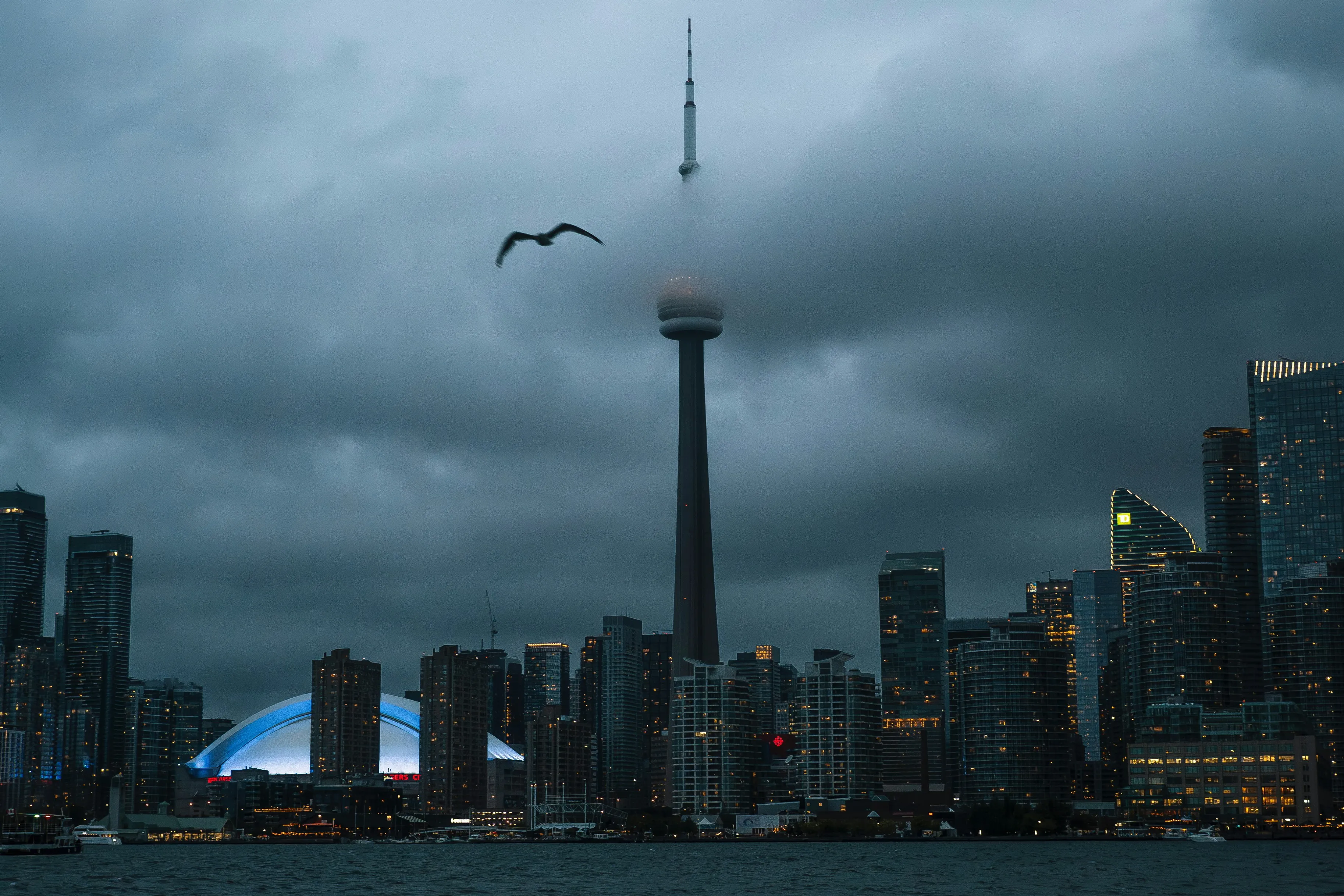 Dramatic Toronto Skyline: CN Tower Emerges Through Moody Clouds
