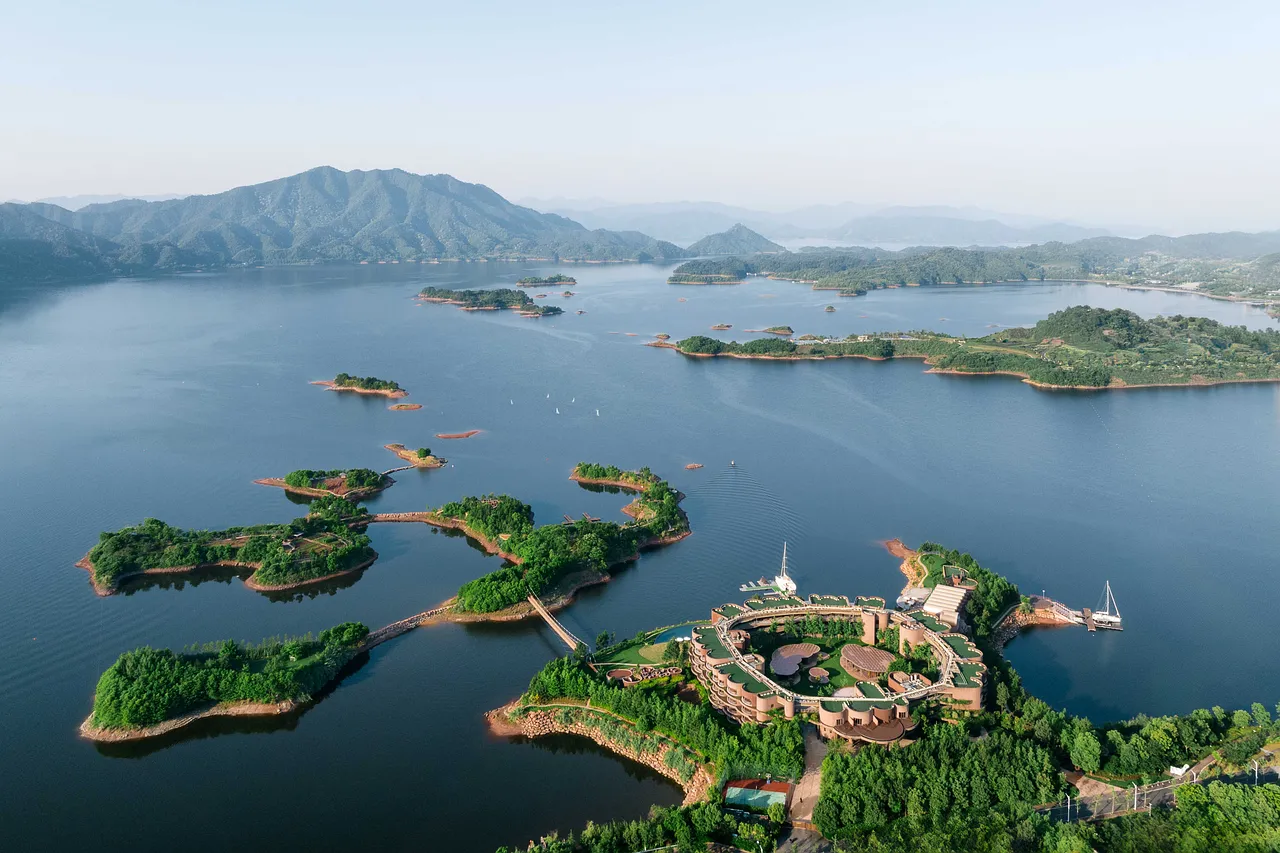 Breathtaking Aerial View: Serene Lake, Islands & Mountain Resort
